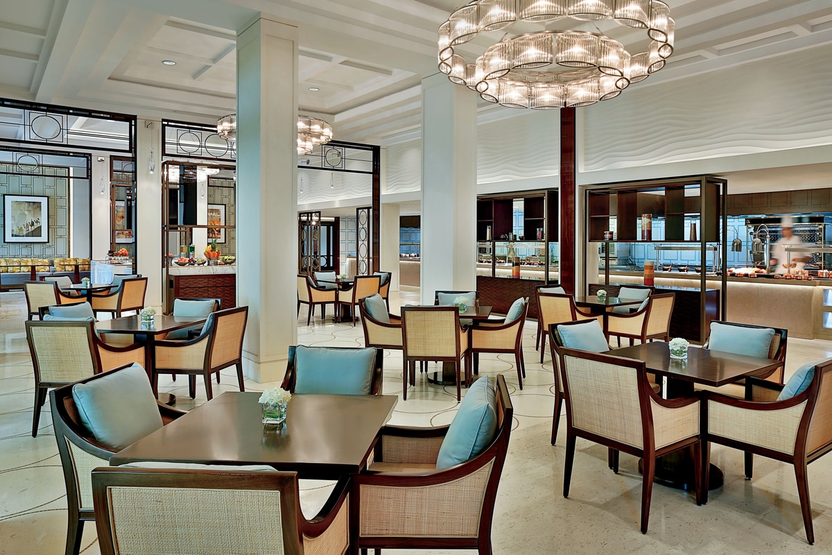 Elegantly relaxed dining room with tall ceilings, geometric screens and dark wood accents